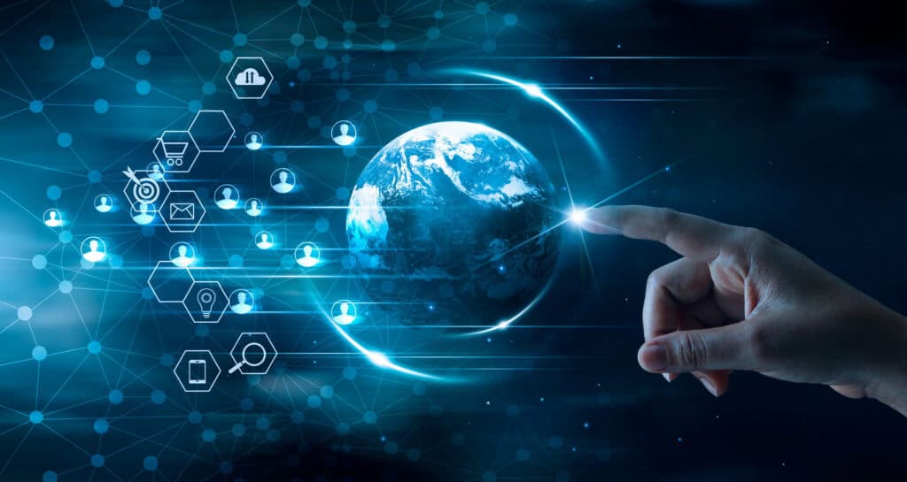 A hand touches a glowing digital Earth, surrounded by a network of interconnected tech icons like cloud, shopping cart, email, and user profiles, against a dark blue background.