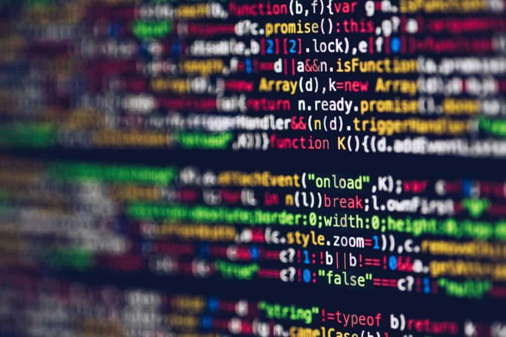 Close-up of colorful computer code on a dark screen, with some lines in focus and others blurred.