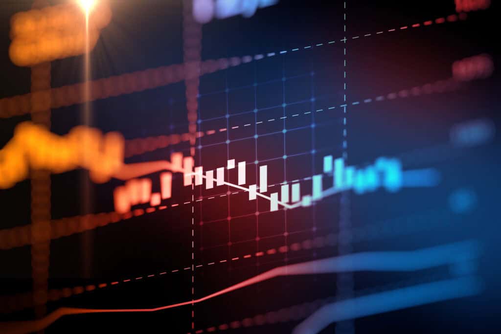 A digital display of financial data with glowing candlestick bars and line graphs on a dark grid background, featuring red, blue, and orange elements and a lens flare.