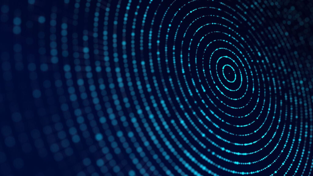 Abstract image of glowing blue dots forming concentric circles on a dark blue background, with some areas blurred.
