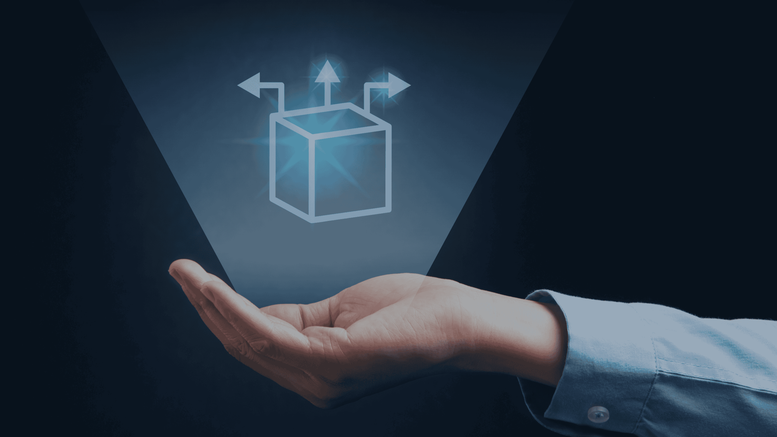 A hand holding a glowing holographic cube with arrows pointing left, up, and right.
