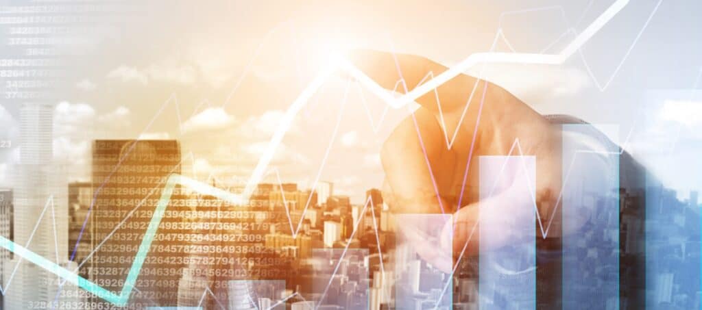 A composite image showing a blurred cityscape, a human hand, and various overlaid financial graphs and numerical data, symbolizing business and financial growth.