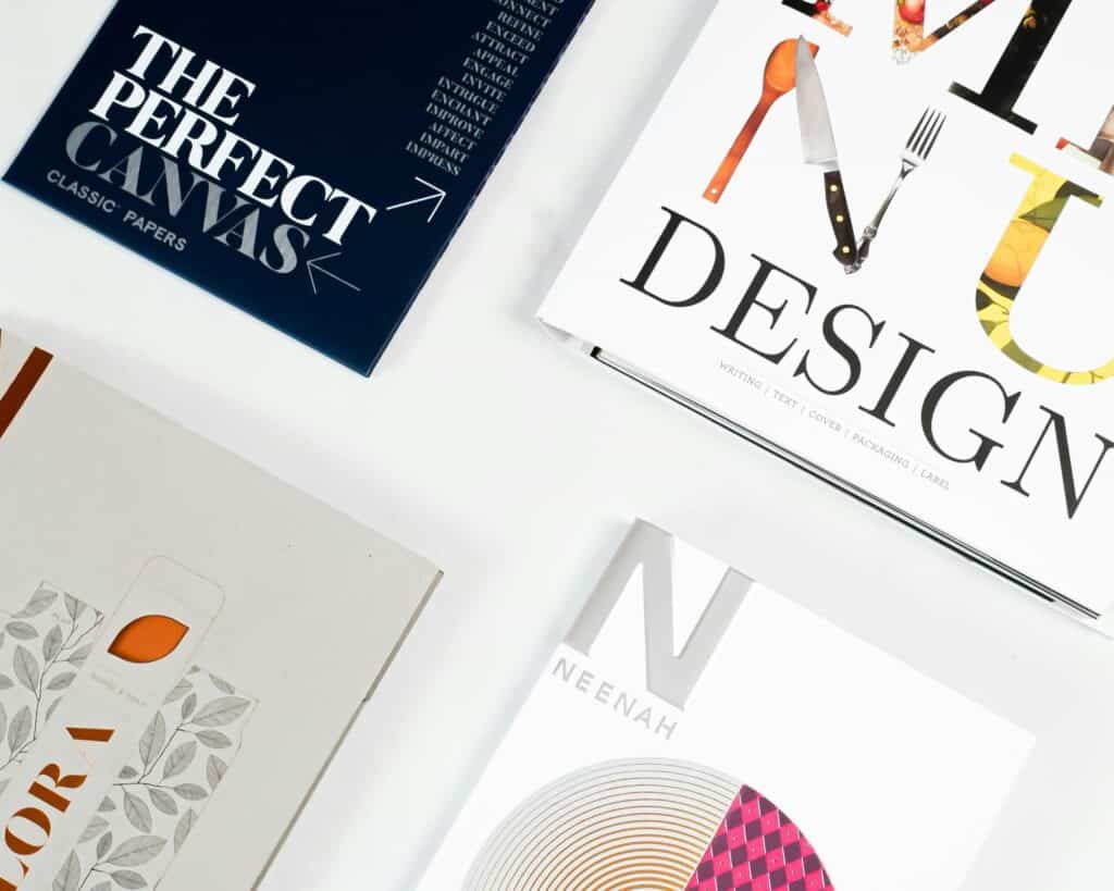 Four paper design samples, including "The Perfect Canvas" and "Design" binders, on a white background.