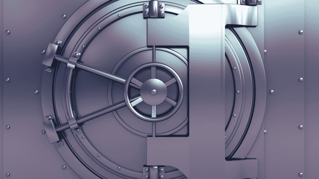 A large, metallic bank vault door with a central spoked wheel, radial locking bars, and riveted concentric rings.