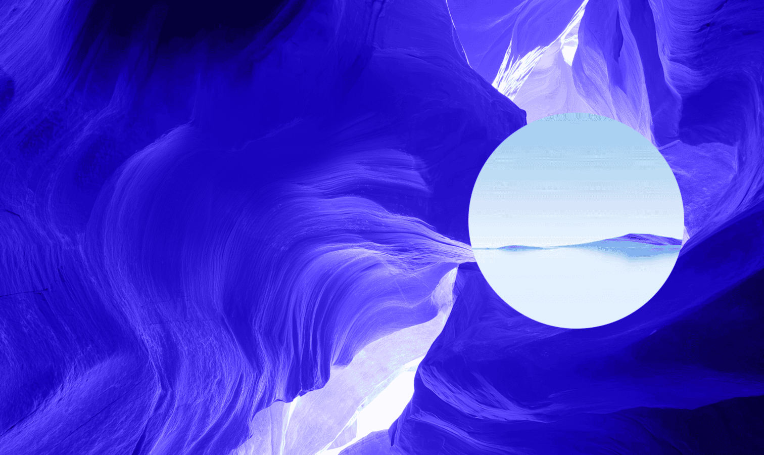 An abstract image of a vibrant blue, sculpted canyon-like formation with a circular cutout revealing a serene landscape of calm water and distant blue hills under a light sky.