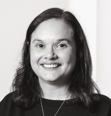 Black and white headshot of a smiling woman with dark hair.