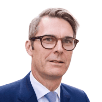 Headshot of a man with short, light brown hair and glasses, wearing a dark suit and light blue tie.