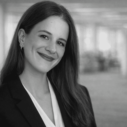 Black and white portrait of a smiling young woman with long dark hair, wearing a blazer and blouse.