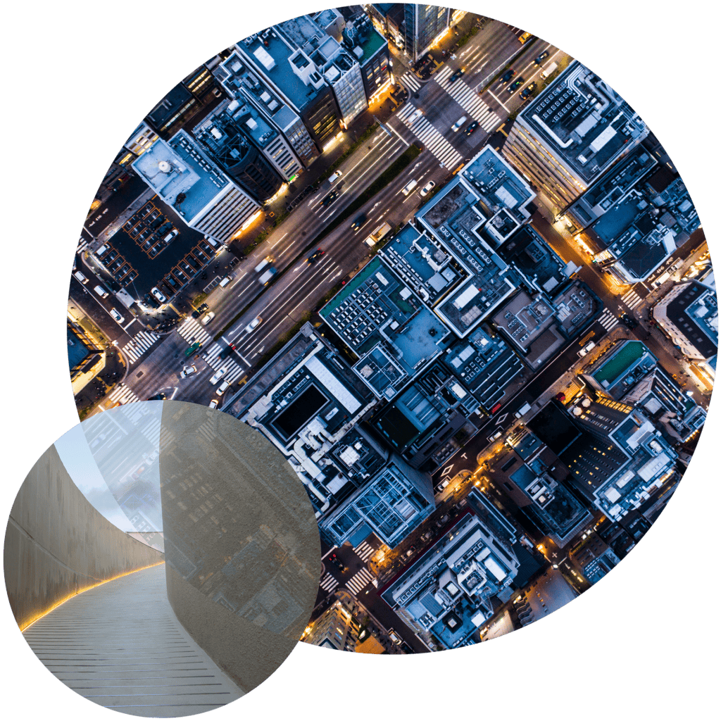 Two circular images on a black background. The larger circle shows an aerial view of a city at night with illuminated buildings and streets. The smaller circle shows a curved concrete wall with warm strip lighting and a faint city reflection.
