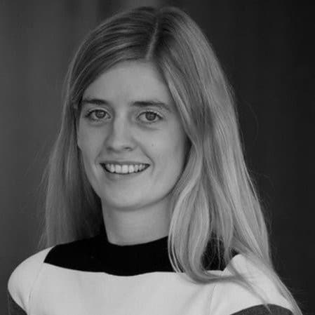 Black and white headshot of a smiling woman with long, light-colored hair looking forward.