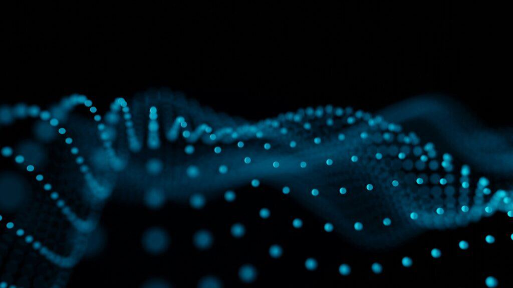 Abstract image of glowing teal-blue dots forming a wave-like pattern on a black background, with some dots in focus and others blurred.